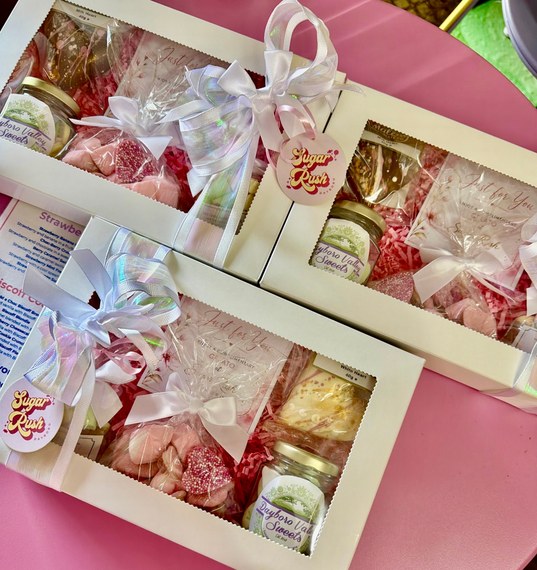 Three styled Sugar Rush gift boxes with blush ribbons, sweet treats, candles and gelato vouchers